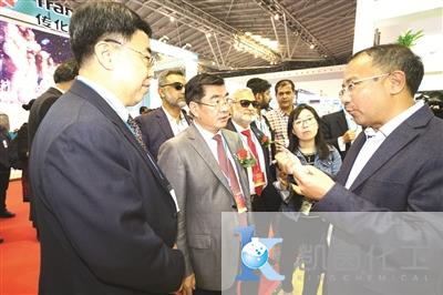 图为龙盛集团董事长阮伟祥(右一)在展台前向傅向升(左二)和史献平(左一)等介绍公司发展情况。(本报记者 张育 摄)